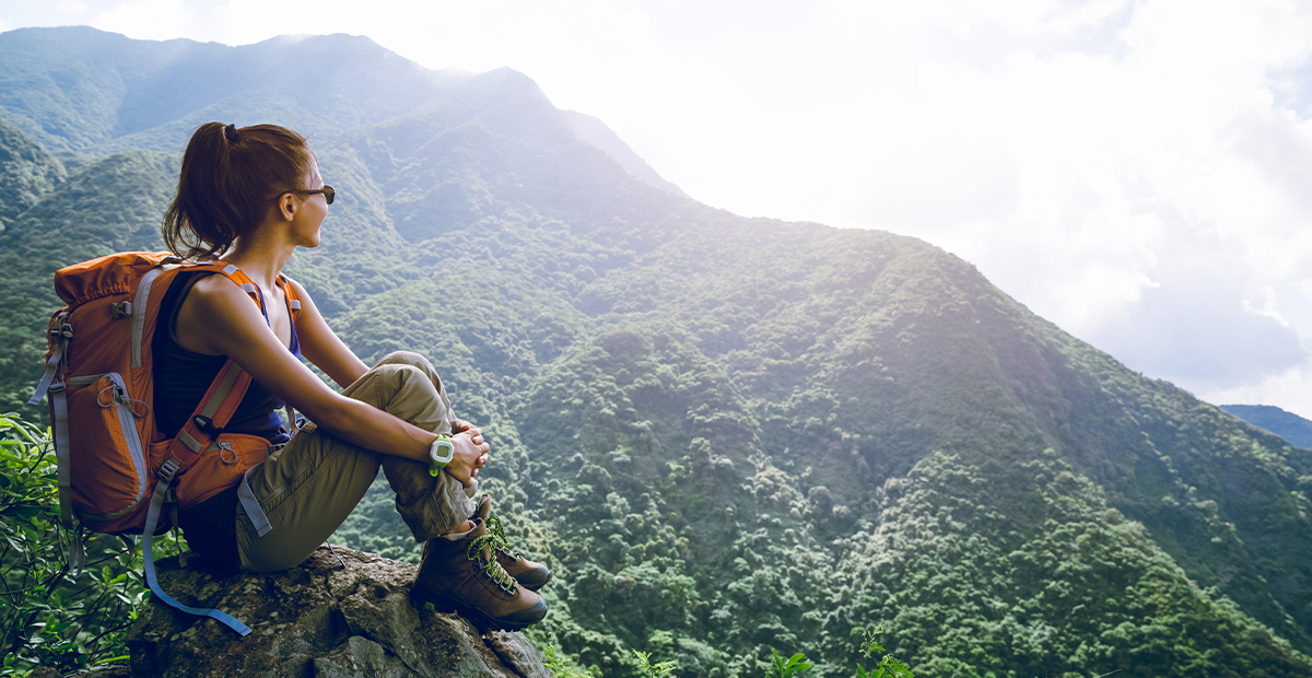 Woman hiker sitting enjoying a mountain view.